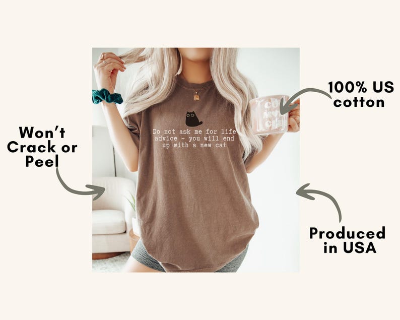 May include: A brown short-sleeve t-shirt featuring a small black cat graphic and the white text: Do not ask me for life advice - you will end up with a new cat. The shirt is made of 100% US cotton and is produced in the USA with a durable print.
