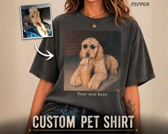 May include: A charcoal gray short-sleeve t-shirt featuring a graphic print of a light brown curly-haired dog wearing round sunglasses and drinking from a plastic cup with a straw. The text "Your text here" is printed below the dog graphic.