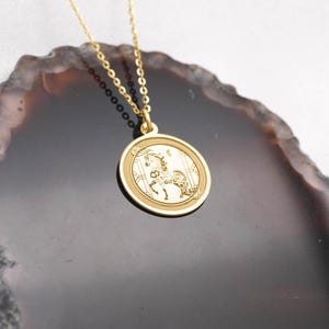 Macro close-up of the 14k solid gold Year of the Horse medallion pendant, focusing on the engraved horse artwork and bright reflective polish. Inspired by Chinese zodiac symbolism of vitality, confidence, and forward progress, this coin necklace suits minimal style and daily wear. SEO: Chinese zodiac pendant, horse necklace, astrology necklace, lunar new year gift, gold charm necklace, handcrafted fine jewelry with crisp detailing.