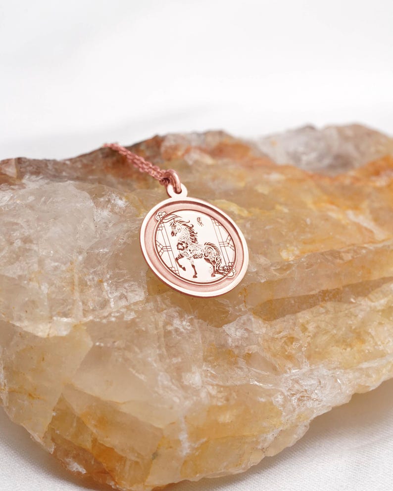 Gift-ready presentation of the 14k solid gold Chinese zodiac Horse medallion necklace, arranged with a clean minimal aesthetic to show scale and shine. The Year of the Horse meaning—confidence, vitality, and fearless movement—makes it a memorable Lunar New Year or birthday gift. SEO phrases: horse pendant necklace, zodiac jewelry, chinese new year gift, astrology necklace, solid gold medallion, personalized engraving charm.