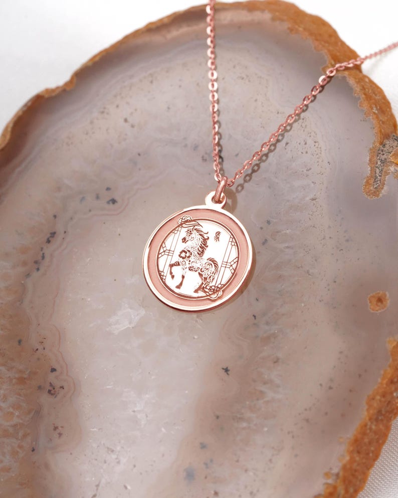 Close-up of a 14k rose gold Chinese zodiac horse medallion necklace, highlighting the soft blush metal color and detailed engraved Horse design. Inspired by Year of the Horse symbolism—confidence, vitality, and progress—this pendant is ideal for daily wear and gifting. Keywords: rose gold zodiac necklace, horse pendant, lunar new year gift, chinese new year jewelry, astrology necklace, handmade coin pendant with a smooth back for engraving.