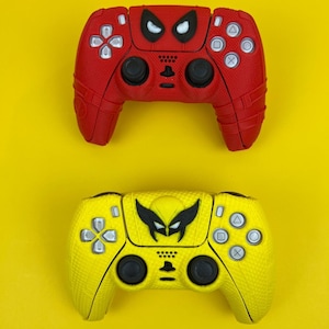 May include: Two video game controllers, one red with a black Spiderman design and one yellow with a black Wolverine design.
