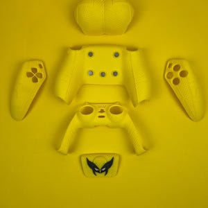 May include: A yellow Xbox controller skin with a Wolverine character design. The skin is made up of separate pieces for the front, back, and sides of the controller.