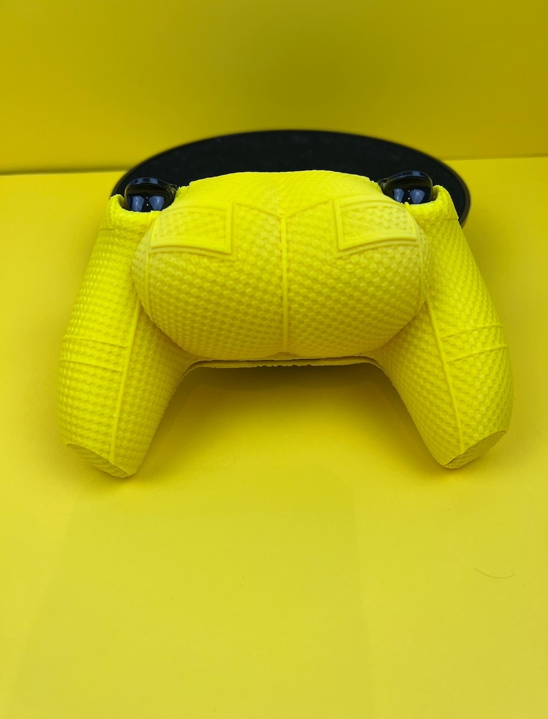 May include: A bright yellow textured silicone controller cover for a gaming console.