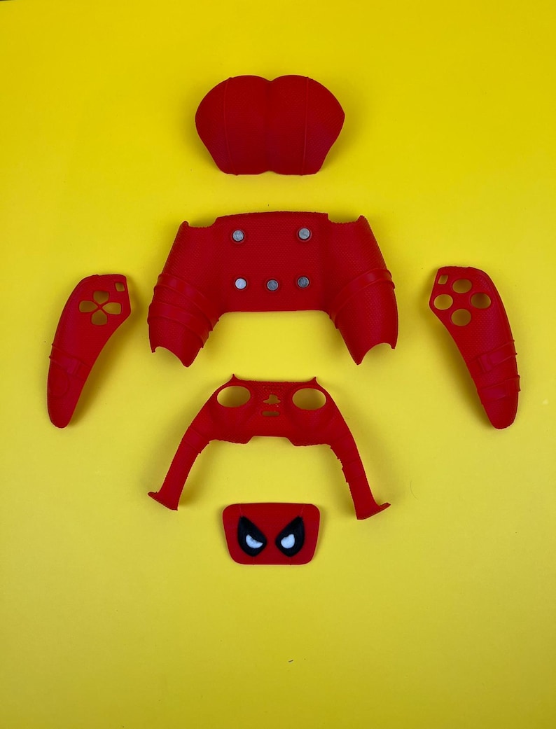May include: Red and black video game controller faceplate with a spider-man design. The faceplate is made up of six separate pieces, including the front, back, and two side panels.