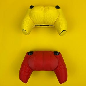 May include: Two video game controllers, one yellow and one red, on a yellow background.