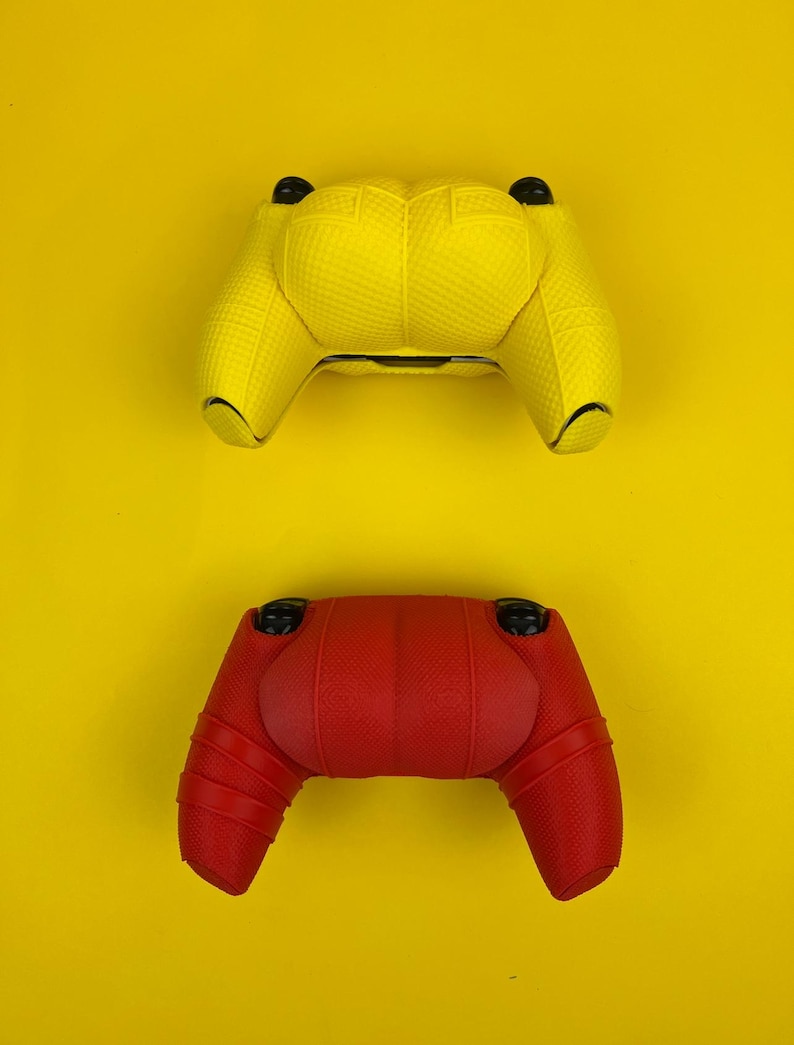 May include: Two video game controllers, one yellow and one red, on a yellow background.