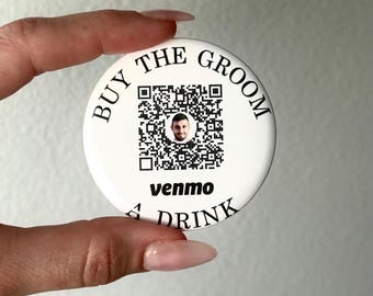 May include: White round button with black text that says "Buy the Groom a Drink". A QR code with a man's face in the center is surrounded by the text. The text "venmo" is below the QR code.