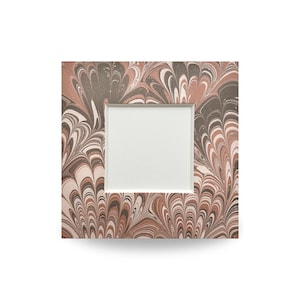 May include: Square picture frame with a marbled pattern in shades of brown, white, and gray. The frame has a white interior border surrounding the empty space for a photo. The frame is a decorative item.