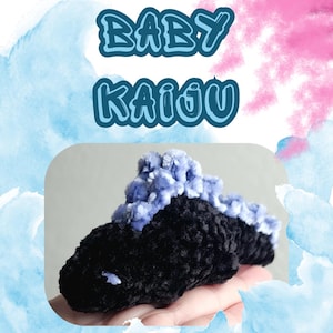 以下が含まれることがあります： 青いふわふわのトップが付いた黒色の、かぎ針編みのBaby Kaijuが表示されています。画像には「Baby Kaiju」と「Crochet Pattern beginner level」の文字が含まれています。背景は、青とピンクの色合いの水彩効果があります。