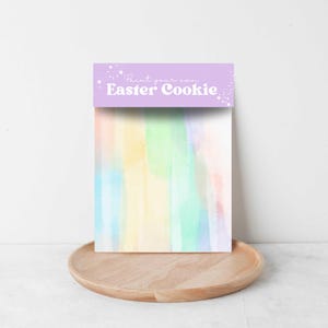 May include: A printable Easter cookie design with a watercolour background of pastel colours. The text "Print your own Easter Cookie" is on a purple banner.