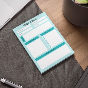 May include: A light blue study session notepad with teal accents. The notepad includes sections for subject, date, course, task list, and notes. The words "Study Session" are printed at the top. A pen and laptop are visible in the background.