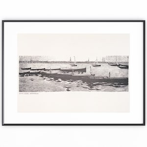 Könnte beinhalten: Schwarz-Weiß-Druck in einem Rahmen, der eine Hafenszene mit mehreren Booten und Segelbooten zeigt. Das Kunstwerk ist eine detaillierte Illustration mit Vintage-Ästhetik. Der Druck befindet sich in einem schwarzen Rahmen vor einem weißen Hintergrund.