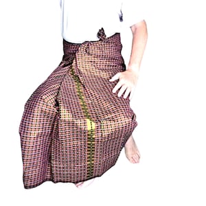 以下が含まれることがあります： 赤と黒のチェック柄のラップスカートで、金色のトリムが付いています。スカートはウエストで結ばれており、白いシャツと合わせています。