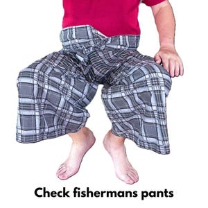 May include: Checkered fisherman's pants in shades of gray and white. The pants are wide-legged and tied at the waist. The text "Check fisherman's pants" is at the bottom of the image. The person is wearing a red shirt.