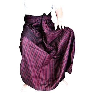 以下が含まれることがあります： 濃い赤と黒のストライプ模様の長いスカート。スカートはウエストで結ばれており、足首まで届いています。