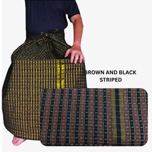 May include: A sarong featuring a brown and black striped pattern with thin gold vertical lines. The fabric displays a repeating grid-like texture with small white diamond accents throughout the weave. The text BROWN AND BLACK STRIPED is visible.