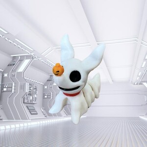 May include: A white Zero figurine from The Nightmare Before Christmas. The figurine has large black eyes, a small orange pumpkin on its head, and a red collar. The figure is in a futuristic setting.