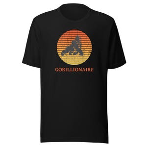 May include: Black t-shirt with a retro-style sunset graphic featuring a gorilla and the text "GORILLIONAIRE".