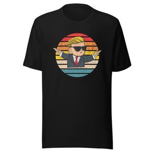 Könnte beinhalten: Schwarzes T-Shirt mit einer Retro-Illustration einer Cartoon-Figur, die eine Sonnenbrille und einen Anzug trägt und vor einem Sonnenuntergang steht.