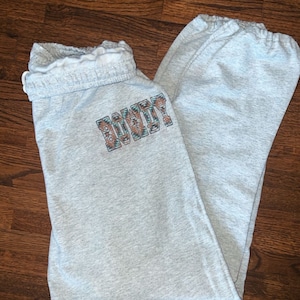 May include: Gray sweatpants with a colorful "BOHO" graphic on the left leg.