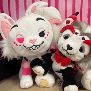 May include: Two plush toys: a white bunny with pink accents and a gray dog with red accents. The bunny has a winking eye and a mischievous grin. The dog has a red bow tie and heart details. Both have black and white paws.
