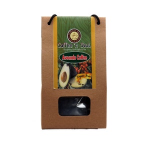 以下が含まれることがあります： 紐の取っ手が付いた茶色の紙袋。袋には「Coffee 'n Soul」と「Avocado Coffee」と書かれたラベルが付いています。ラベルには「Sugar Free」と「100 g」の文字も書かれています。ラベルにはアボカドの絵が描かれています。