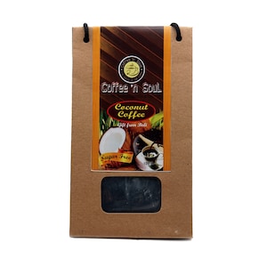 May include: A brown paper bag with a black handle and a rectangular window. The label reads "Coffee 'N Soul" and "Coconut Coffee, Gift from Bali, Sugar Free." The image shows a coconut and a cup of coffee. The product is a 100-gram bar.
