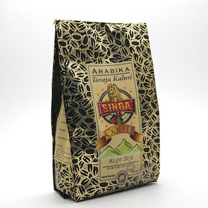 May include: A black and gold patterned coffee bag with the text "Arabika Toraja Kalosi" and "Singa Coffee." The bag features a lion emblem and a mountain graphic. The bag contains 150 grams of coffee.