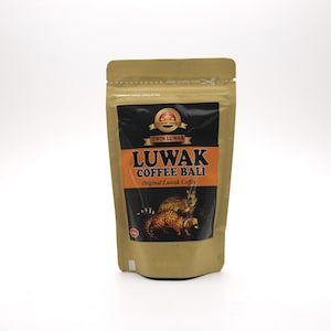Op de afbeelding: Een verpakking Luwak Coffee Bali. De verpakking is bruin met een zwart en oranje etiket. Het etiket bevat de woorden "Luwak Coffee Bali" en een illustratie van twee civetkatten. De verpakking is verzegeld.