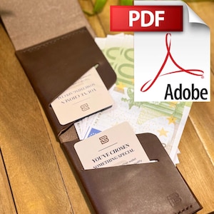Puede incluir: Una cartera de cuero marrón con dos ranuras para tarjetas, una abierta y otra cerrada. La ranura abierta muestra una tarjeta con el texto "YOU'VE CHOSEN SOMETHING SPECIAL". La cartera está sobre una superficie de madera con dinero en efectivo y un icono PDF en el fondo.