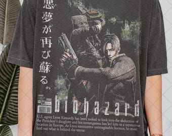 May include: Dark gray t-shirt featuring a graphic from the video game "Biohazard." The design includes two characters, one holding a gun, with Japanese text and the game's title. A description of the game is printed below the title.
