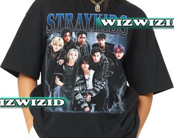 May include: Black t-shirt featuring a graphic print of a K-pop group called "Stray Kids". The print depicts the band members in a dark and edgy style.