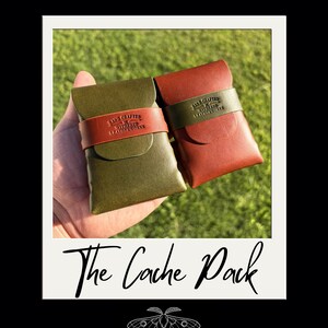 May include: Two leather card holders, one olive green and one reddish-brown, each featuring a contrasting leather strap embossed with the text Hand Crafted by Withered Leatherworks. The image includes the text The Cache Pack and a moth icon.