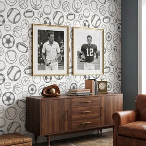 Può includere: Una stanza con decorazioni a tema sportivo. Le pareti sono coperte da una carta da parati con motivi di vari palloni sportivi. Due foto in bianco e nero incorniciate di atleti sono appese sopra un mobile in legno. Una poltrona in pelle e un tappeto intrecciato completano la scena.
