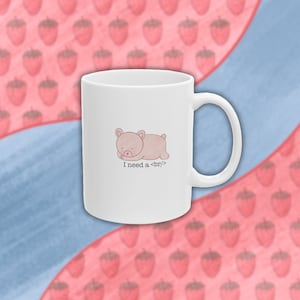 May include: White ceramic mug with a pink cartoon bear sleeping on it. The text "I need a <br>" is printed below the bear.