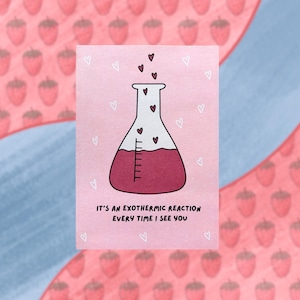 May include: A pink greeting card with a cartoon illustration of a laboratory flask filled with red liquid and floating hearts. The text reads, "IT'S AN EXOTHERMIC REACTION EVERY TIME I SEE YOU."