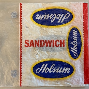 May include: A white plastic sandwich bag with red scalloped edges. The bag has a blue and yellow logo that says "Holsun" and the words "Sandwich" in red.