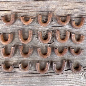 Può includere: Una tazza di ceramica bianca con manico nero e la scritta "But First, Coffee" in nero, con un carattere a mano. La tazza è su una superficie bianca.