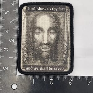 May include: Black and white embroidered patch with a portrait of Jesus and the text "Lord, show us thy face and we shall be saved".