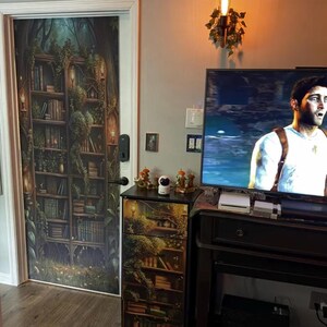 Peut inclure: Une housse de porte et une housse de meuble &agrave; tiroirs assortie pr&eacute;sentant un motif imprim&eacute; d'une biblioth&egrave;que en bois sombre envahie par la v&eacute;g&eacute;tation, remplie de livres, de vignes et de petites lanternes lumineuses.