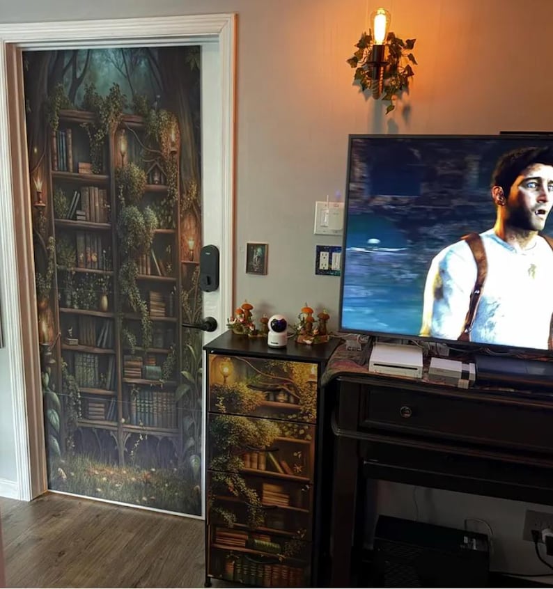 Peut inclure: Une housse de porte et une housse de meuble &agrave; tiroirs assortie pr&eacute;sentant un motif imprim&eacute; d'une biblioth&egrave;que en bois sombre envahie par la v&eacute;g&eacute;tation, remplie de livres, de vignes et de petites lanternes lumineuses.