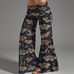 May include: Wide-leg pants with a dark blue background and a repeating pattern of moths in shades of brown, green, and tan. The pants feature a high waist and a drawstring tie. The design includes stars and crescent moons.