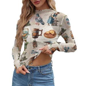 Pode incluir: Uma blusa bege de manga comprida com gola alta e babados. A blusa apresenta um padrão repetido de ilustrações vintage, incluindo pombos, um ferreiro, uma caneca de madeira e alimentos. O tecido transparente adiciona um toque delicado.