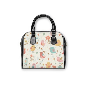 May include: A black leather handbag with a white background featuring a repeating pattern of colorful birds, flowers, and hearts.