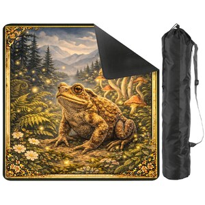 May include: A yoga mat featuring a detailed illustration of a toad in a forest scene with mushrooms and a mountain backdrop. The mat has a black underside and is accompanied by a black carrying bag with a shoulder strap.