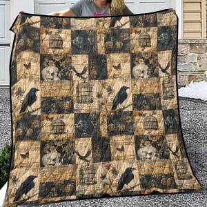 Könnte beinhalten: Eine Patchwork-Decke mit einem gotischen Design, die schwarze Raben, Vogelkäfige, Totenköpfe und Schmetterlinge auf einem braunen und schwarzen Hintergrund zeigt. Die Decke hat einen schwarzen Rand und ist aus weichem, gestepptem Material gefertigt.