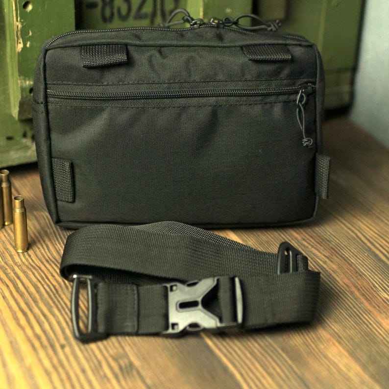 May include: A black fanny pack with a zippered pocket and an adjustable strap. The strap has a buckle closure.