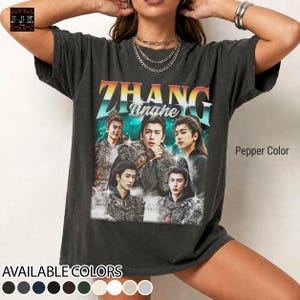 May include: Pepper color t-shirt featuring a graphic of five people with the text "ZHANG Tinghe" in a retro style. The shirt also has the text "AVAILABLE COLORS" and a color palette at the bottom.