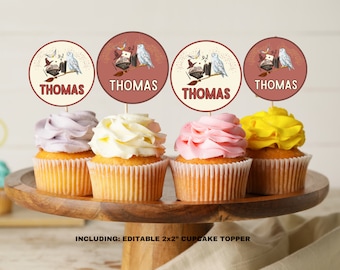 Op de afbeelding: Vier cupcakes met verschillende gekleurde frosting, bedekt met ronde cupcake toppers met een witte uil, een boek en een toverstaf met de naam "THOMAS" op elke topper. De tekst "INCLUDING: EDITABLE 2x2" CUPCAKE TOPPER" staat onderaan de afbeelding.